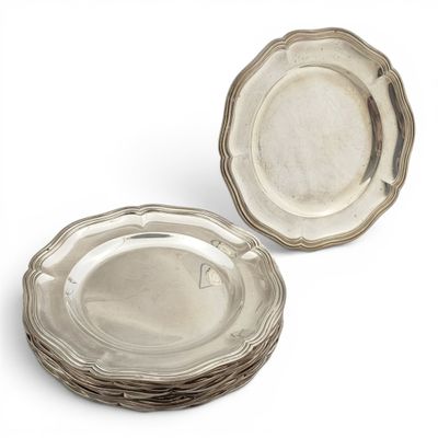 two silver plated dishes sitting on top of each other on a white surface