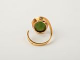 a close up of a gold ring with a green stone