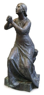 statue of a woman sitting on a bench with her hands clasped