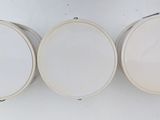 three white circular mirrors mounted on a wall next to each other
