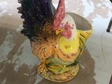 une figurine représentant un poulet posée sur une table, à côté d'une paire de ciseaux