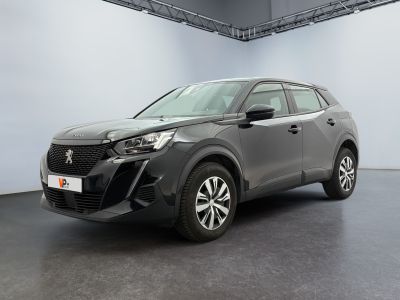 Une voiture grise est garée dans une grande pièce dont le plafond…