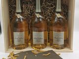trois bouteilles de champagne dans un coffret en bois accompagnées d'un petit mot