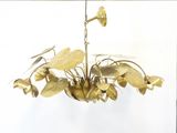 a gold chandelier with flowers hanging from it ' s ceiling
