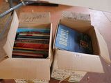 two boxes of books sitting on the floor next to each other