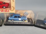 three toy cars are sitting in a display case on a table