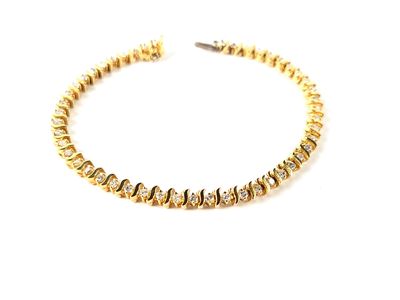 gros plan d'un bracelet en or sur fond blanc