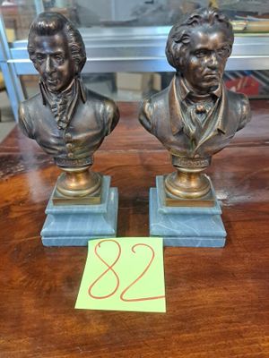 deux bustes en bronze représentant deux hommes assis sur une table