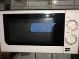 un micro-ondes blanc avec un autocollant bleu dessus