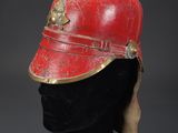 a red and gold helmet on a black mannequin head