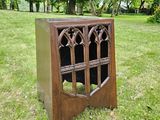 a small wooden cabinet in the middle of a grassy field