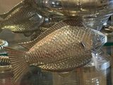 une table en verre sur laquelle se trouve un poisson en argent