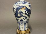 chinese blue and white vase with a dragon on a pedestal