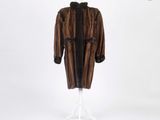 un manteau de fourrure marron et noir posé sur un pied de mannequin