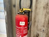 un extincteur fixé au mur d'un immeuble