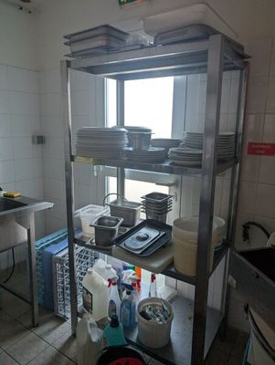 a kitchen with many dishes on the shelves and dishes on the counter