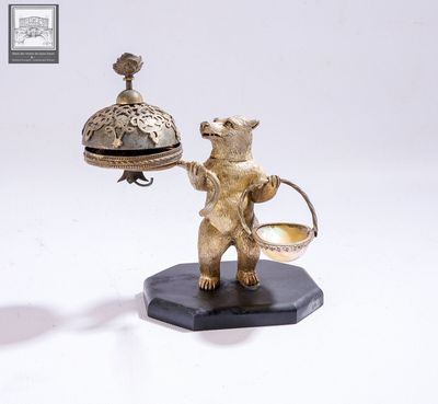 une statue représentant un ours tenant une cloche et un panier