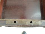 a wooden tray with holes in it and a person standing next to it