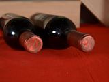 three bottles of wine sitting on a red table