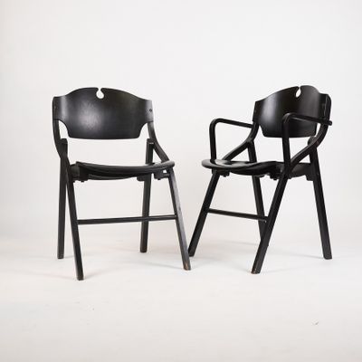 pair of black folding chairs against a white background