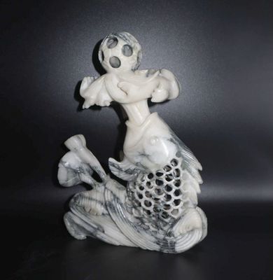 une figurine représentant un poisson sur lequel est perché un homme