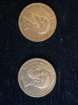 deux pièces d'or posées sur une table recouverte d'un tissu noir