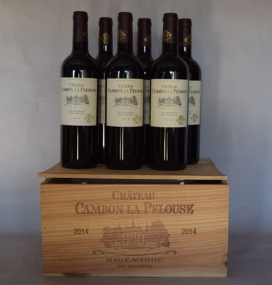 quatre bouteilles de vin rouge dans un coffret en bois posé sur une table