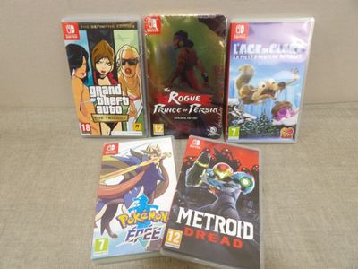 four nintendo wii games sitting on a couch