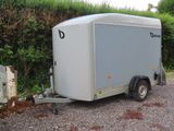 a trailer that is parked in a gravel lot