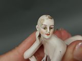 a small figurine of a woman sitting on top of a person ' s finger