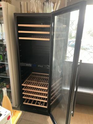 a wine cooler that is open in the kitchen