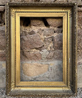 une photo représentant un cadre accroché à un mur de pierre