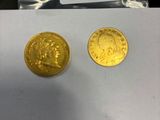deux pièces d'or posées l'une à côté de l'autre sur une feuille de papier