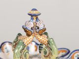 a figurine of a man sitting on top of a bowl