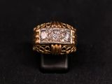 a close up of a gold and diamond ring on a black surface