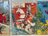 three comic books are lined up on a white surface