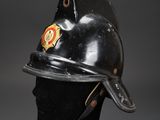 an old fireman ' s helmet on a black mannequin head