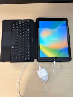 un ordinateur portable et une tablette posés sur une table, avec un chargeur