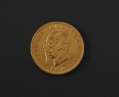 a close up of a gold coin on a black surface