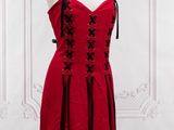 une robe rouge posée sur un pied de mannequin dans une pièce
