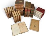 several old books are stacked on top of each other on a white surface