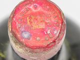 a close up of a wine bottle with a red cap