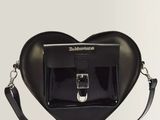 a black heart shaped bag with a metal buckle on a white background