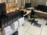 une pièce où il y a beaucoup de cartons et d'ordinateurs par terre