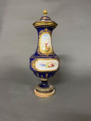 un vase bleu et or orné d'une image représentant une femme