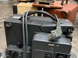 a black camera and a brown suitcase on the floor