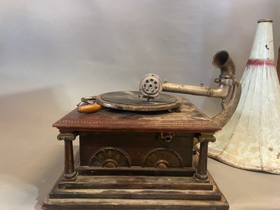 an old record player sitting on top of a table next to a cone
