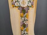 une croix jaune et blanche ornée de fleurs violettes, posée sur un mannequin