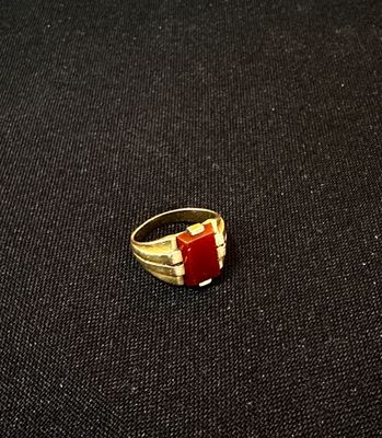 une bague en or ornée d'une bande rouge et blanche