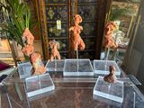 five sculptures of animals on display in a glass case